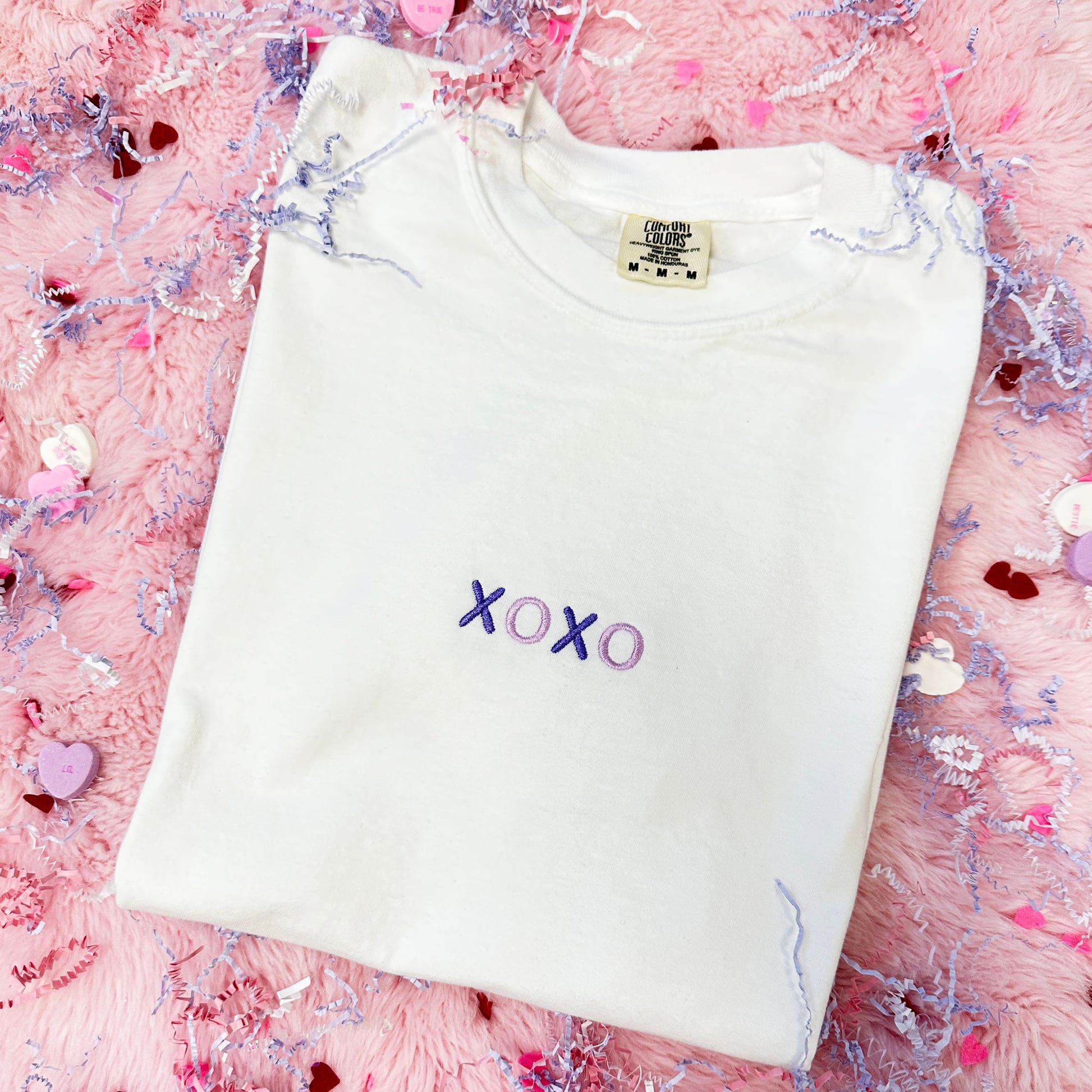White tshirt with xoxo small embroidered across the center chest