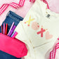 Blue jeans with hot pink pencil pouch and an ivory long sleeve comfort colors top with XOXO school supplies printed design