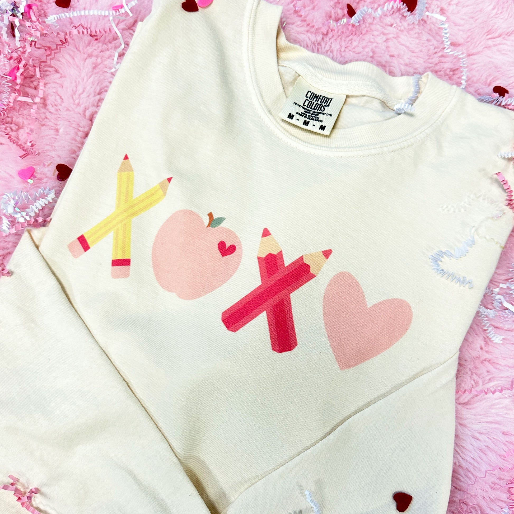 Ivory long sleeve comfort colors shirt with a cute XOXO design made out of school supplies, apple, and heart