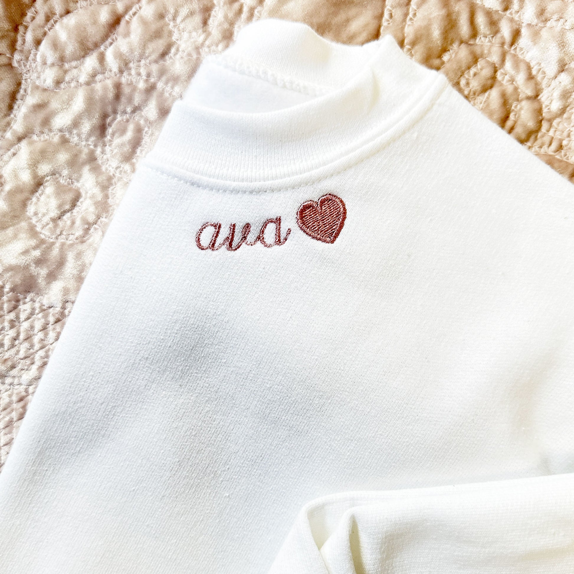 white sweatshirt with custom neckline name and heart embroidery
