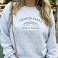 Close up of woman wearing a venice italy travel embroidered crewneck sweatshirt in ash and ivy thread