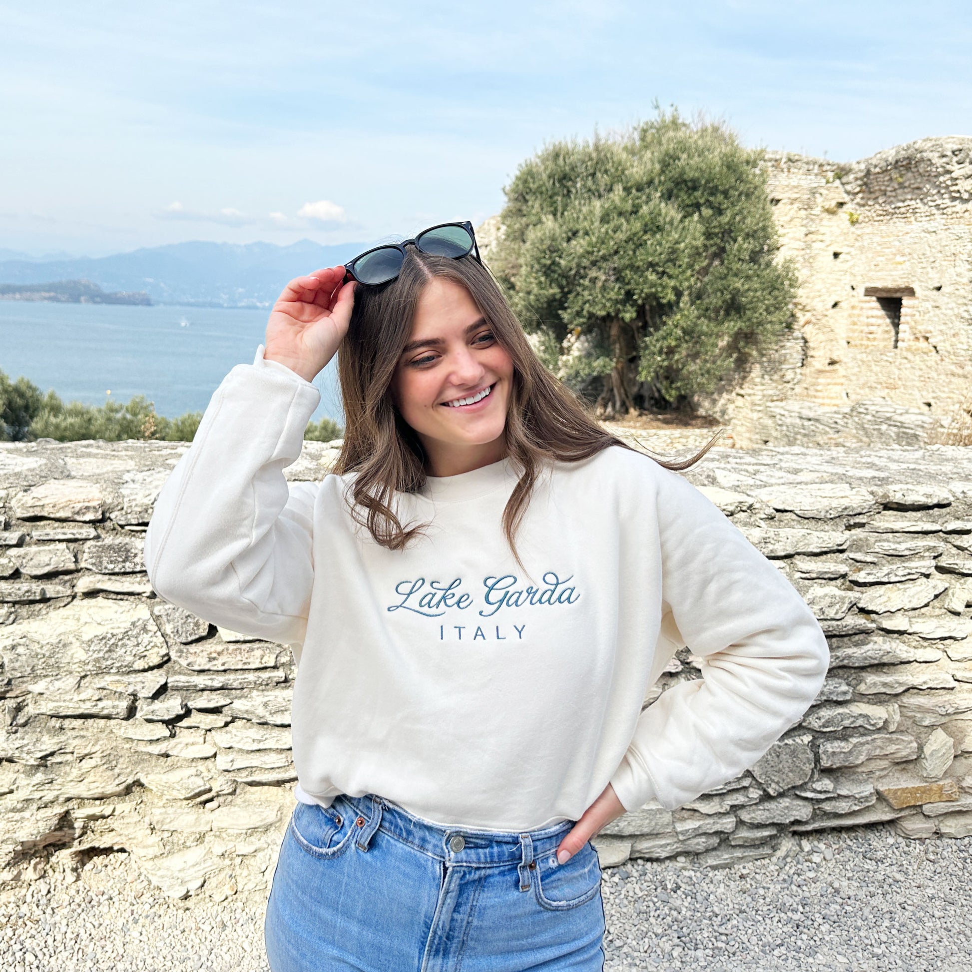 Woman styling s sweet cream crewneck sweatshirt with lake gards italy embroidered in french blue thread