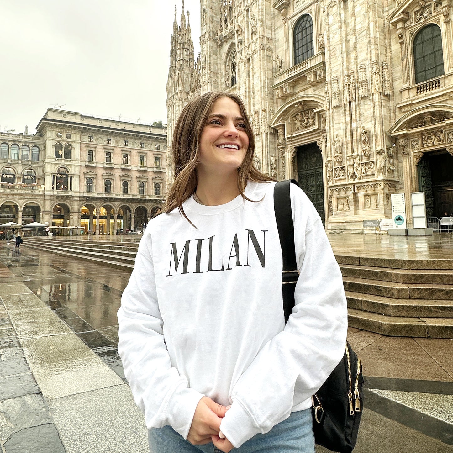 Woman in Milan wearing a printed all caps Milan white sweatshirt in black ink