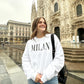 Woman in Milan wearing a printed all caps Milan white sweatshirt in black ink