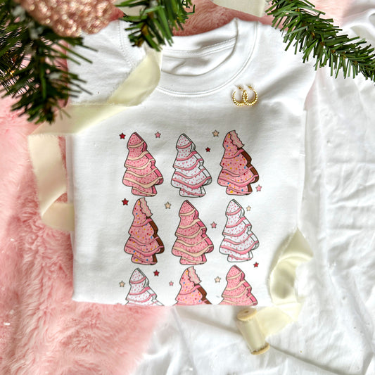 white crewneck sweatshirt with cute pink little debbie christmas tree print on the front under a christmas tree