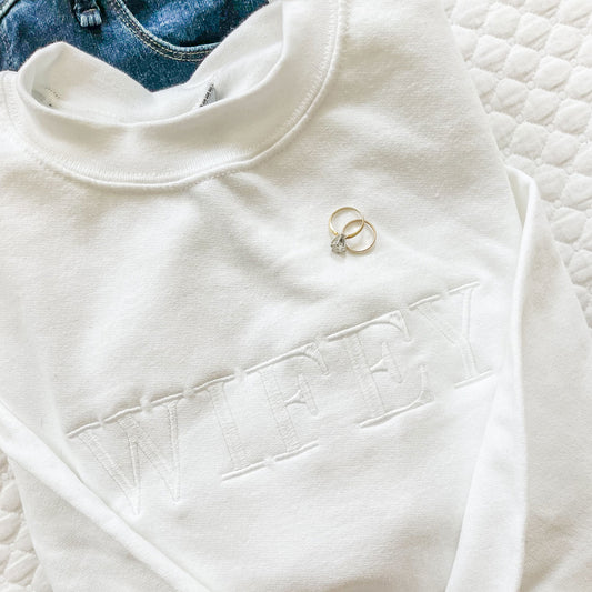 close up of a white on white WIFEY embroidered sweatshirt
