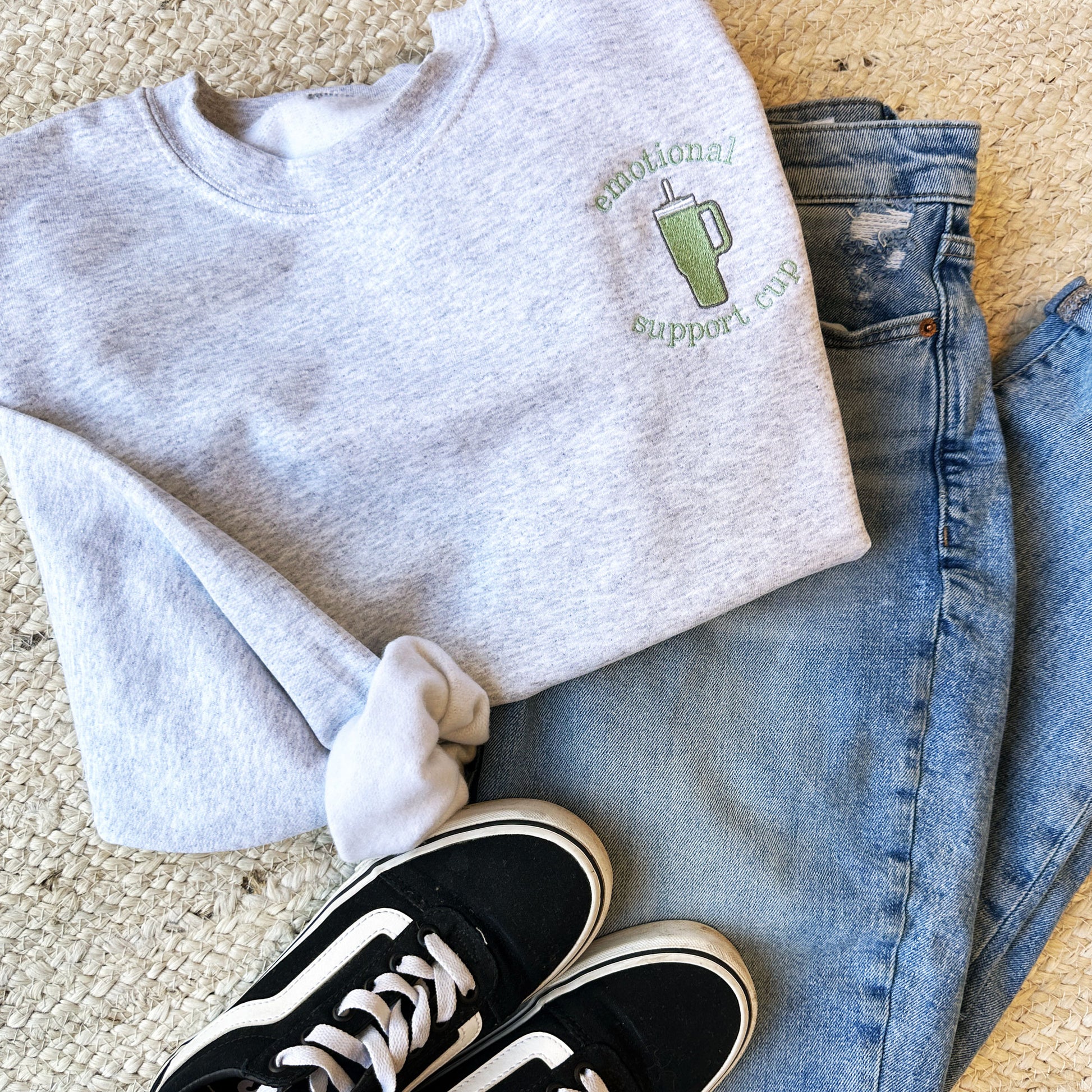image of an outfit featuring black vans, blue jeans, and an ash gray sweatshirt with a tumbler embroidered design