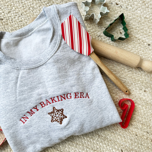 ash crewneck sweatshirt embroidered with an in my baking era cookie design surrounded by cookie cutters