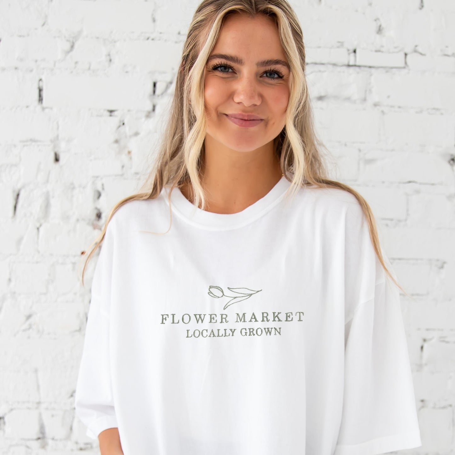 girl wearing white tee with  flower market embroidered design