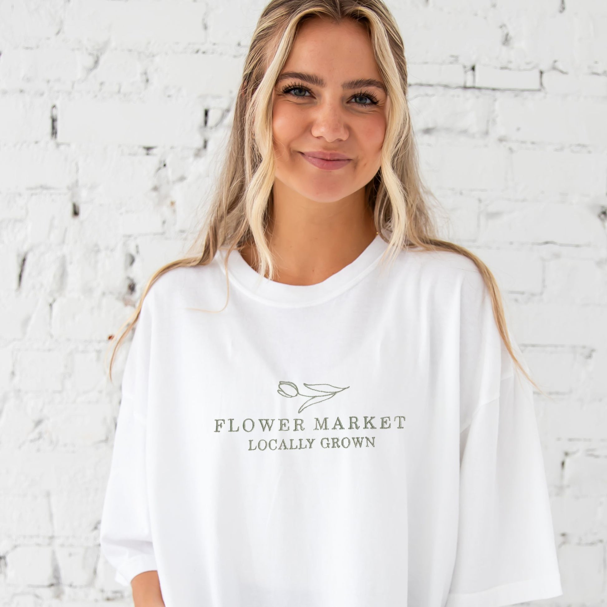 girl wearing white tee with  flower market embroidered design