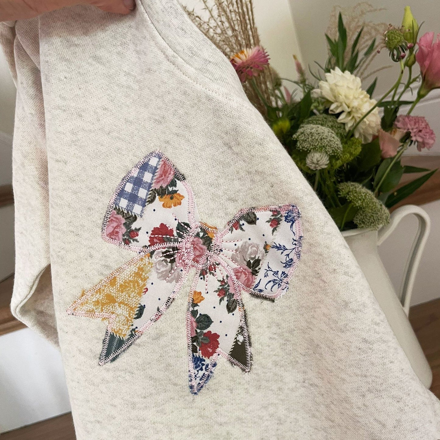 oatmeal heather crewneck with custom embroidered patchwork quilted bow embroidered design