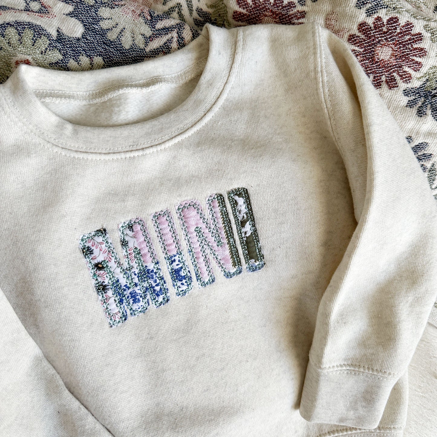 heather oatmeal youth crewneck with a custom MINI embroidered design over a vintage inspired patchwork fabric