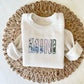 heather oatmeal youth crewneck with a custom MINI embroidered design over a vintage inspired patchwork fabric