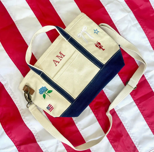 Beige and navy bag with embroidered designs on an American flag background