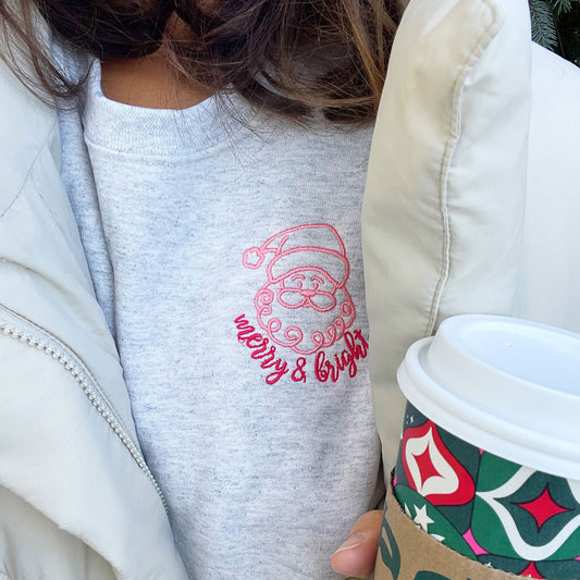 close up of a cute outlined santa and merry and bright embroidered sweatshirt