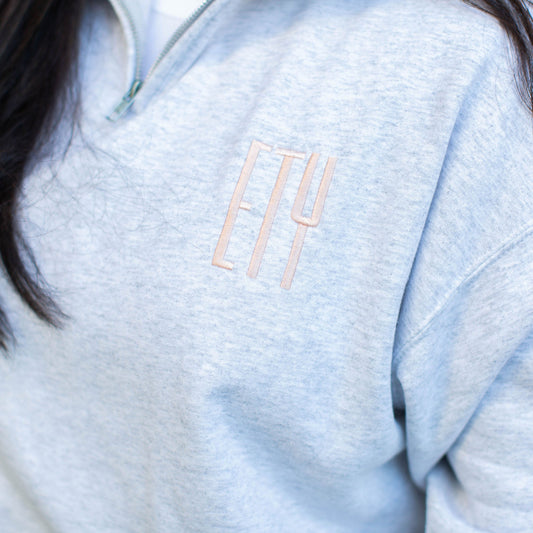 close up of three letter embroidered monogram on ash quarter zip pullover 