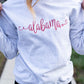 close up of custom state name embroidery across the chest of a gray pullover sweatshirt 