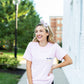 girl wearing personalized pink top with teacher embroidery on pocket