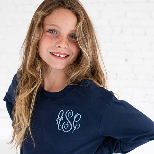 young girl wearing a long sleeved top with custom embroidered monogram.