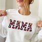 woman wearing a crewneck sweatshirt featuring a MAMA groovy daisy ghost pattern
