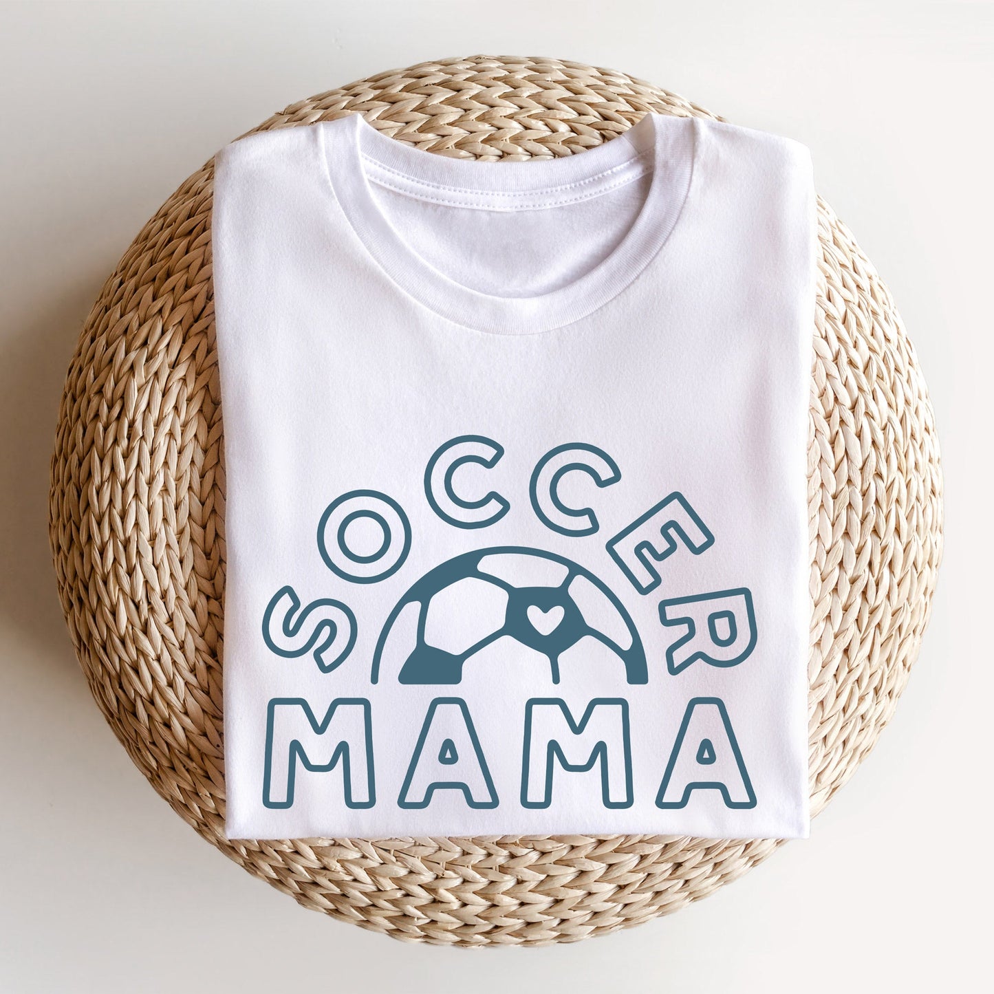 white t-shirt featuring a soccer mama printed desing with a soccer ball and heart in french blue ink
