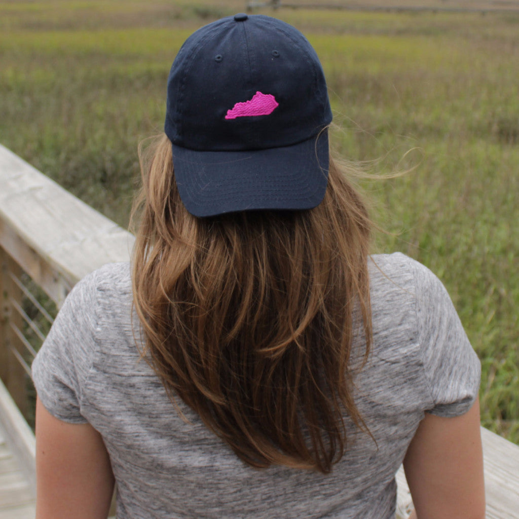 woman wearing a navy baseball cap with a fuchsia kentucky state embroidered design