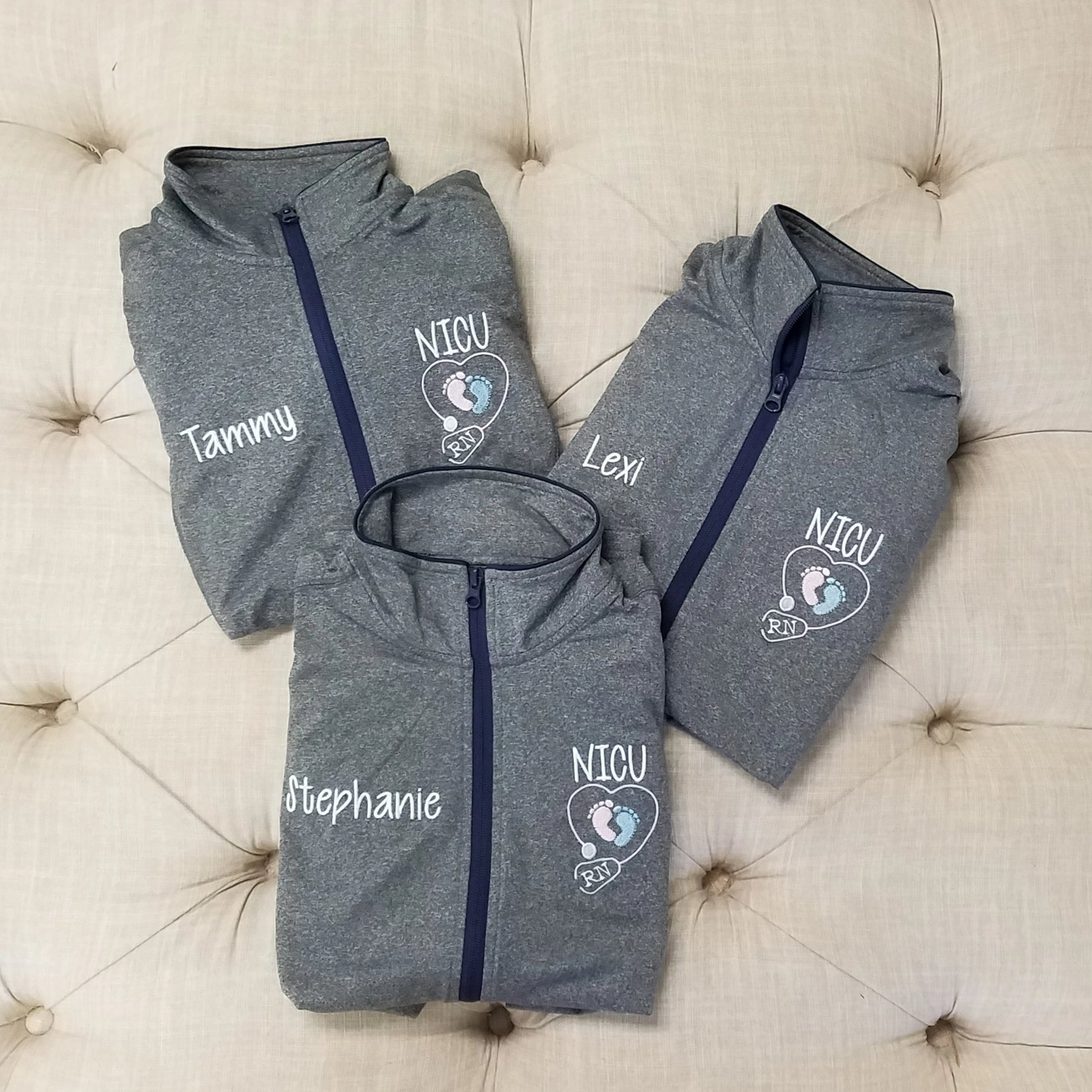 three athletic full zip jackets with a custom name embroidery on the right chest and a NICU baby feet rn stethoscope design on the left chest