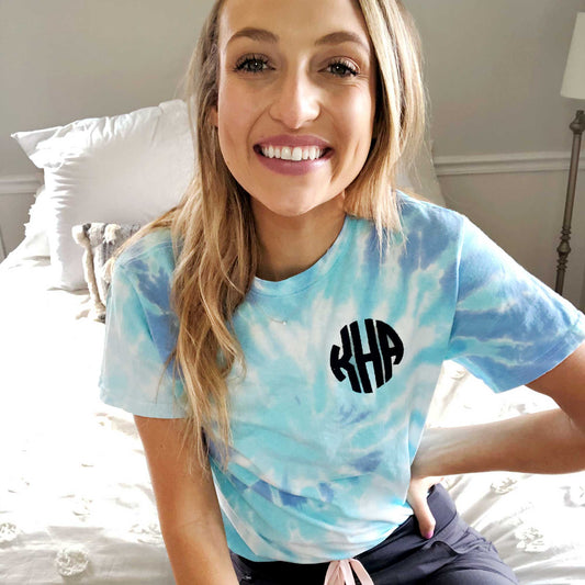 girl wearing a blue spiral tie-dye t-shirt with navy round monogram on left chest