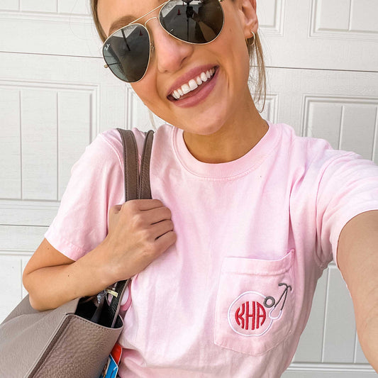 nurse wearing a blossom pink pocket tee featuring a custom round stethoscope embroidery design on the pocket