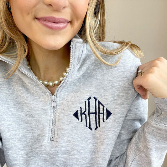 woman wearing custom pullover quarter zip with three letter navy embroidered monogram