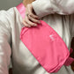 woman wearing a pink nylon fanny pack crossbody with mini embroidered monogram at the top
