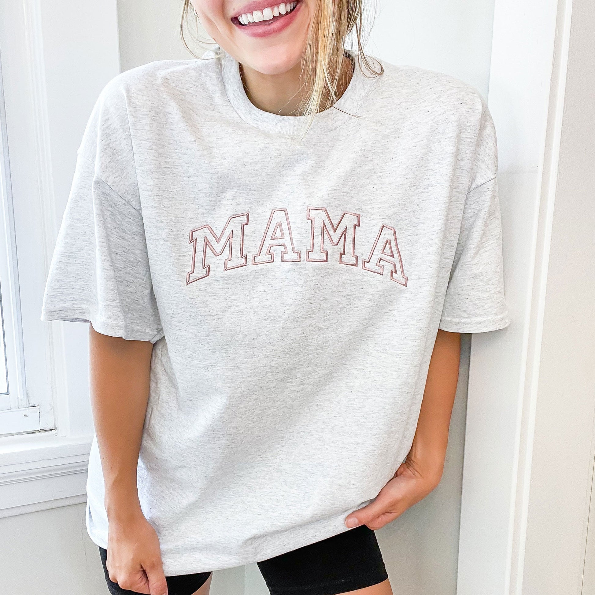 woman wearing oversized tee with mama embroidered in an athletic block font