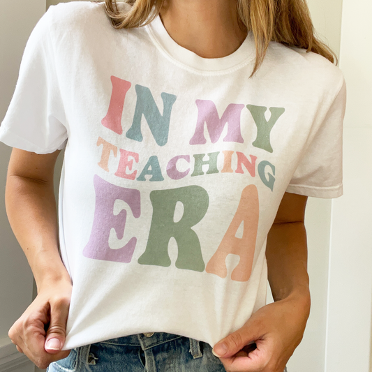 woman wearing white comfort colors t-shirt with a in my teaching era multicolor wavy retro print