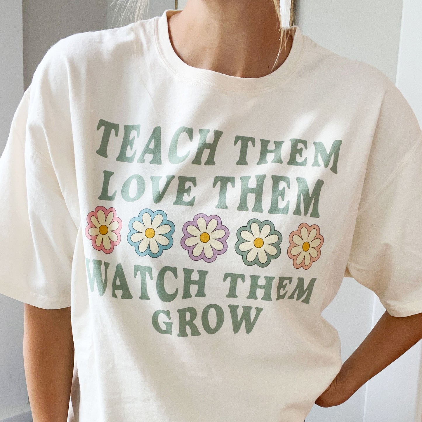 tshirt with a teach them love them watch them grow print with daisies