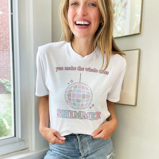 teacher wearing a white comfort colors t-shirt with a custom printed tee with the design of a disco ball and the saying 'you make the whole class shimmer'