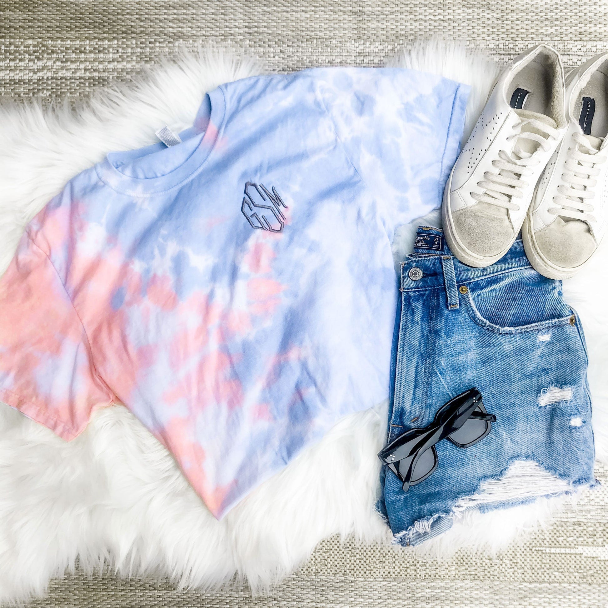 flatlay of outfit featuring coral and blue soft tie dye tee with personalized three letter monogram