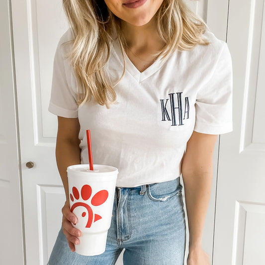 woman wearing jeans and a white v-neck t-shirt with custom navy blue embroidered monogram