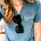 close up of woman wearing a heather denim v-neck tee with fiancee embroidered in white thread