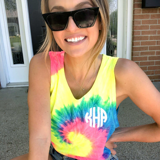 girl wearing a neon tie dye tank top with a circle font white personalized monogram
