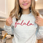 woman wearing a holiday sweatshirt with falala embroidered across the chest in  a script font