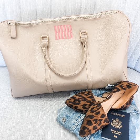 beige vegan leather duffle with hhb embroidered in coral pink thread 