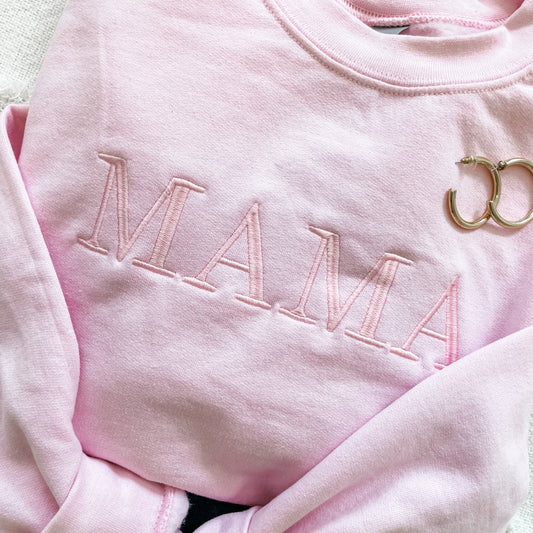 light pink crewneck sweatshirt with embroidered mama in baby pink thread an in all caps across the chest