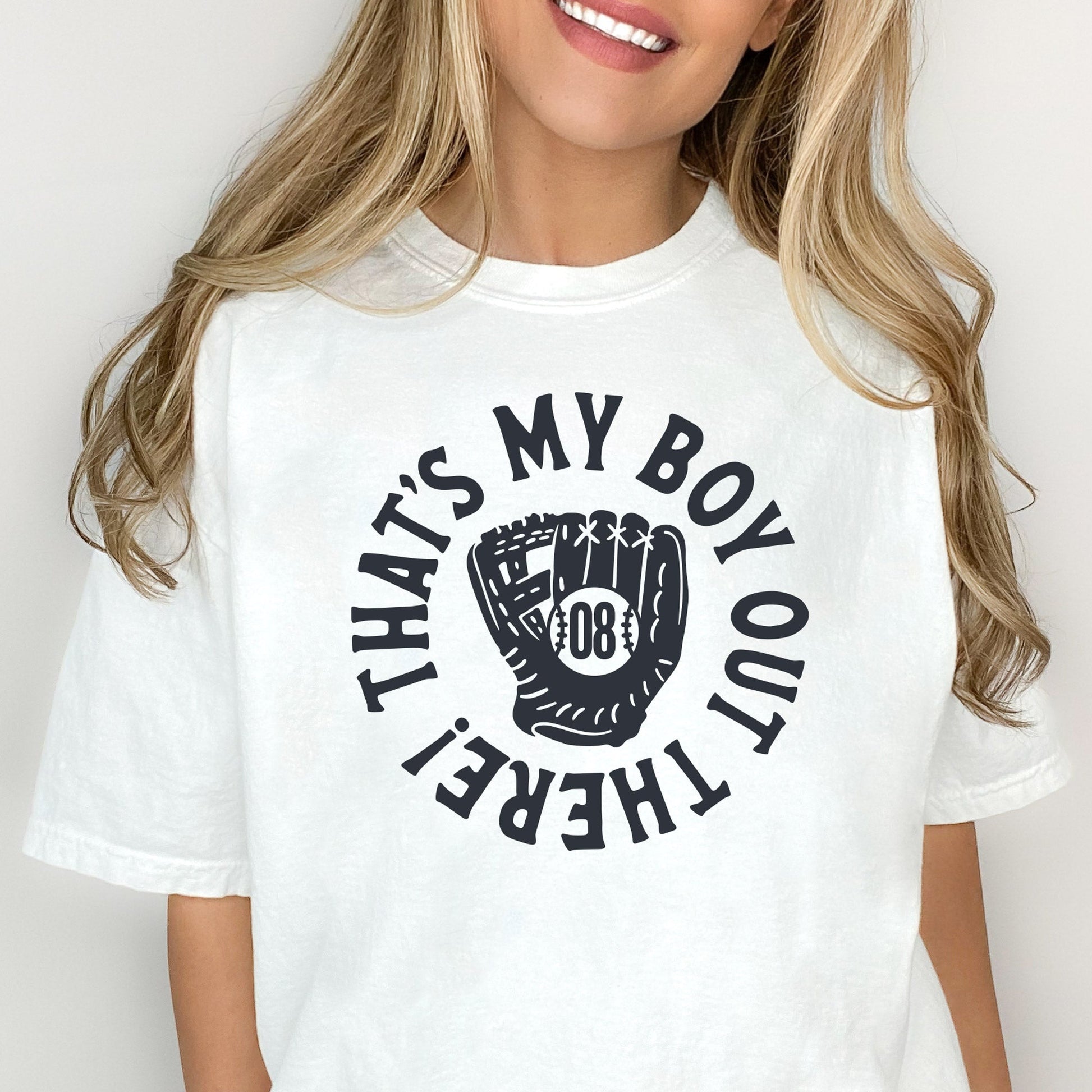 woman wearing a white t-shirt featuring a custom design reading 'that's my boy out there!' with a baseball mitt and custom player number in the center 