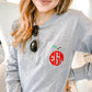 woman wearing an athletic grey long sleeve pocket t-shirt with an apple monogram