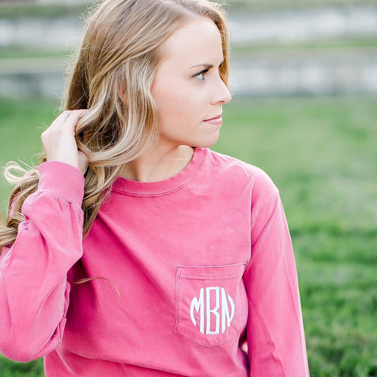 girl wearing a long sleeve pink shirt with personalized monogram embroidered on the pocket 