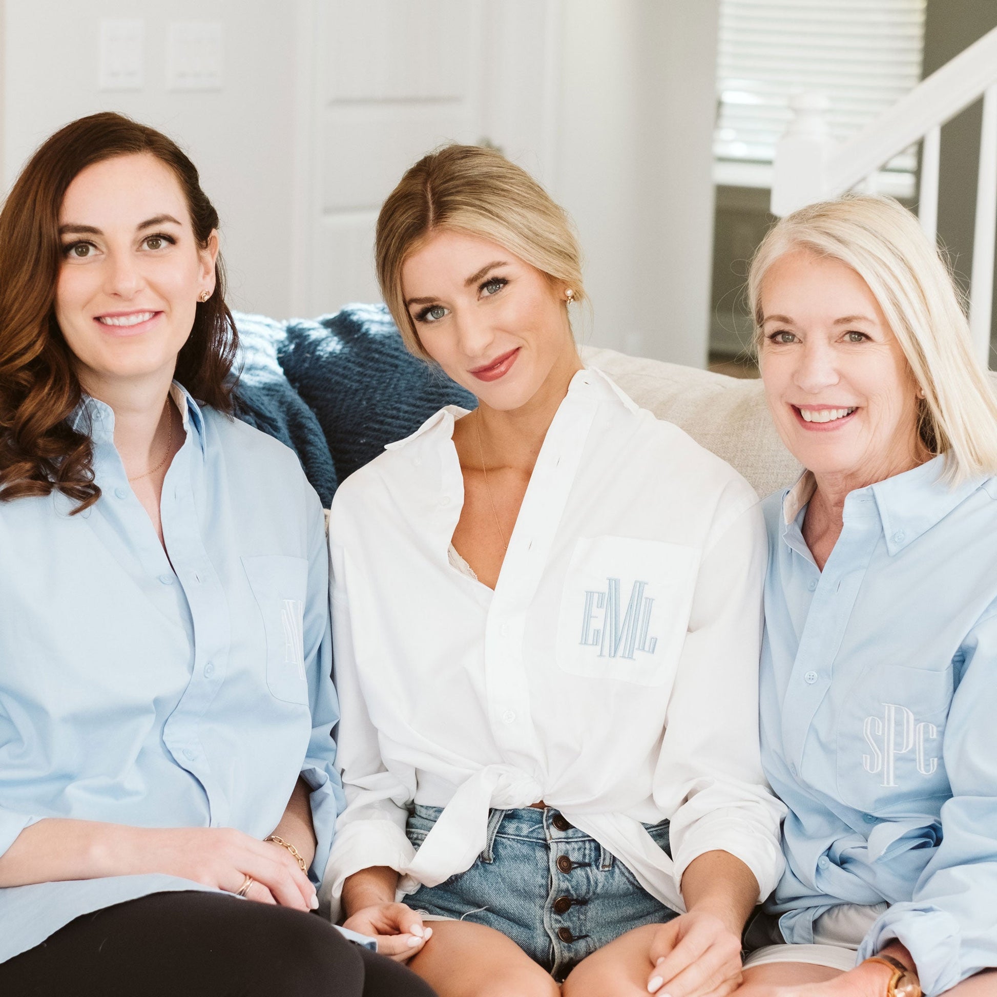 a bride and her bridesmaids wearing button ups in blue and white with custom embroidery on the pocket